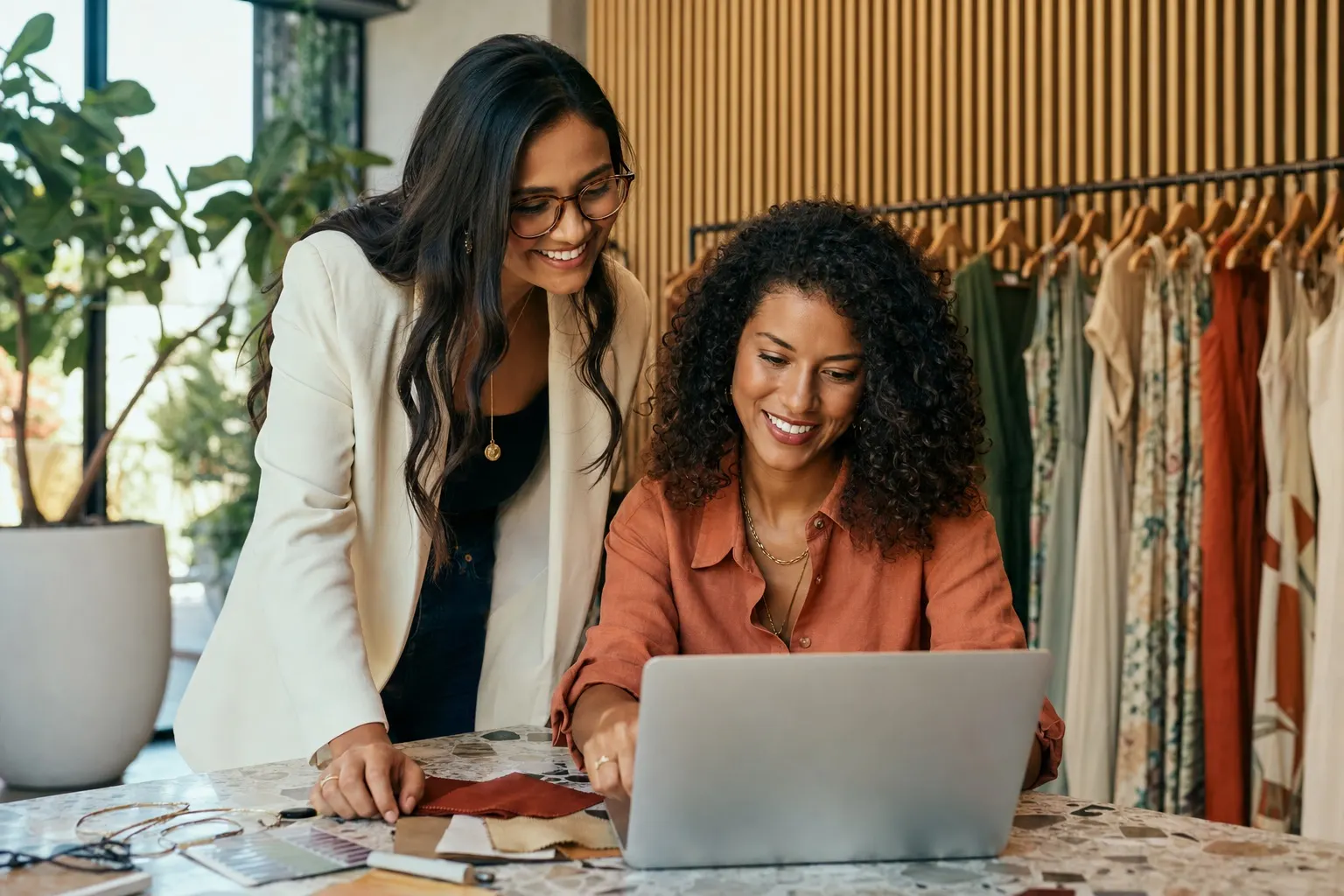 Brazilian fashion entrepreneurs reviewing a wholesale catalog